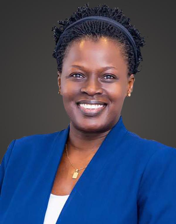 Portrait of a smiling woman in a blue blazer against a dark background.